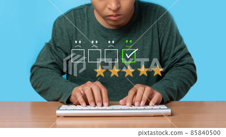 Young man using wireless keyboard with virtual screen on the smiley face icon on the digital touch screen. 85840500