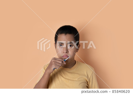 Young man brushing teeth, cleaning teeth isolated on orange studio background. health care dental concept. 85840620