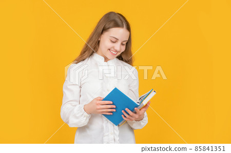 happy teen girl in white shirt ready to study do homework read book on yellow background, reader 85841351