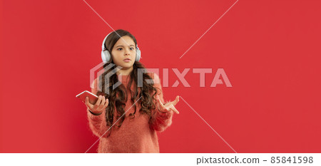 unpleased kid in sweater listen music in earphones hold phone, copy space, technology 85841598