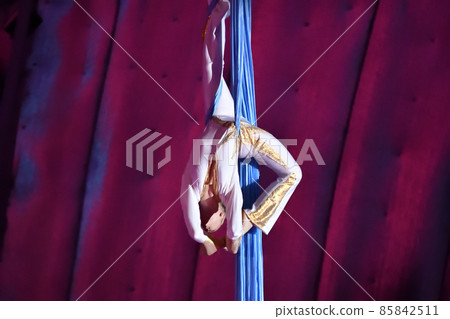 A young aerial gymnast performs her number on ribbons A young aerial gymnast performs her number on ribbons 85842511