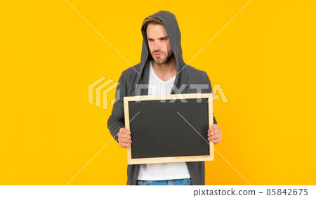 guy with bristle holding chalkboard with copy space on yellow background, here 85842675