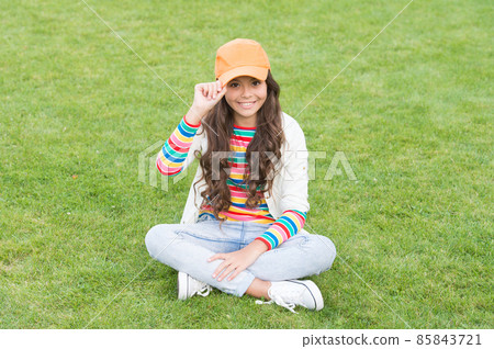Hip hop girl. Happy girl child sit on green grass. Childhood and girlhood. School education 85843721