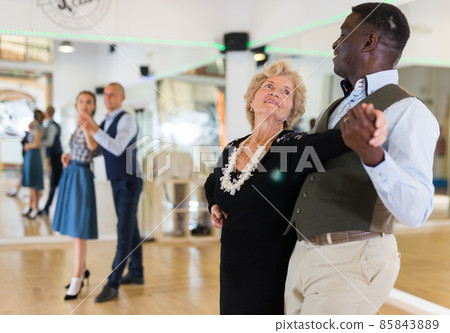 Man and senior woman dancing waltz in studio Man and senior woman dancing waltz in studio 85843889