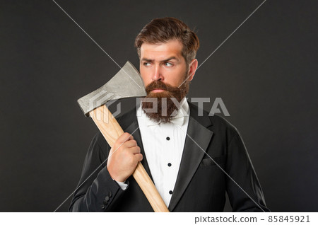 Bearded man hold axe at unshaven face. Axe shaving. Barbering. Barbershop 85845921
