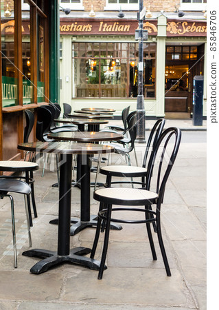 倫敦郊區的里士滿城市景觀：在狹窄後巷的一家商店前排成一排的椅子和桌子 85846706