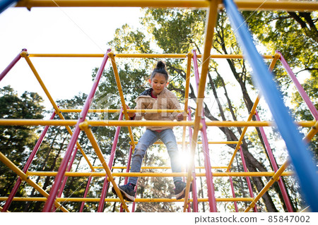 Girl playing in the jungle gym 85847002