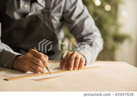 Hands of a male craftsman who designs and designs in the workshop 85847026