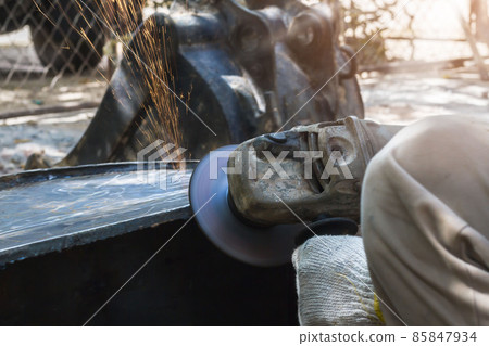 Electric wheel grinding on steel structure in factory 85847934