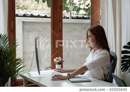 side view of charming smart asian girl entrepreneur use computer work training company career development seminar in home office. 85850840
