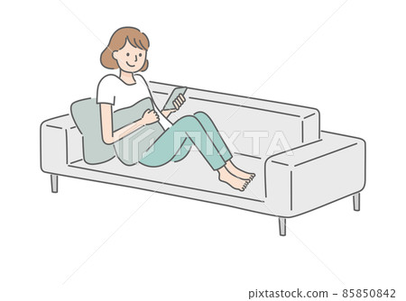 A woman relaxing while looking at her smartphone on the sofa 85850842