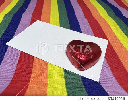 彩虹背景上的心形巧克力和白卡，LGBT/情人節圖像 85850936