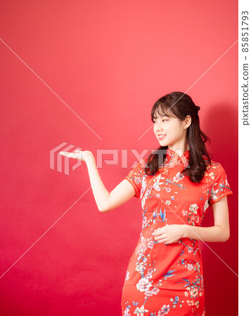 一位身著旗袍的美麗女子,紅色的背景,臉上帶著微笑。 一位身著旗袍的美麗女子,紅色的背景,臉上帶著微笑。 85851793