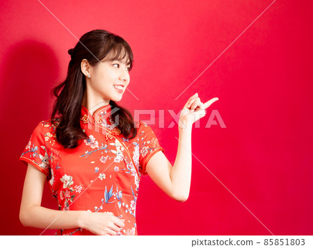 旗袍傳統紅旗旗袍 Toshisuke 婦女紅色黑色背景空白空間微笑由手指寫。 85851803