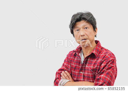 A middle-aged man with a disgusted face with his arms folded 85852135