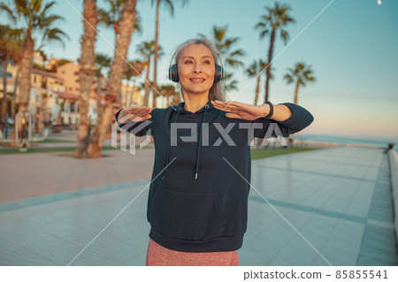 Sporty woman warming up before exercising on the seafront 85855541