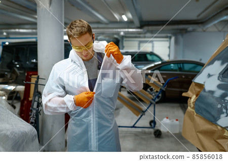 Technician unzipping protective suit after finishing work 85856018