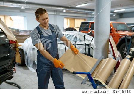 Car repair service workman taking wrapping paper Car repair service workman taking wrapping paper 85856118