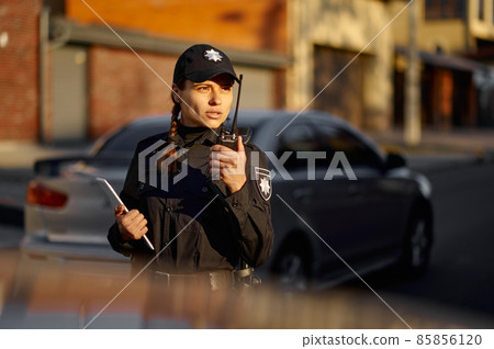 Police woman talking using walkie-talkie during patrolling Police woman talking using walkie-talkie during patrolling 85856120