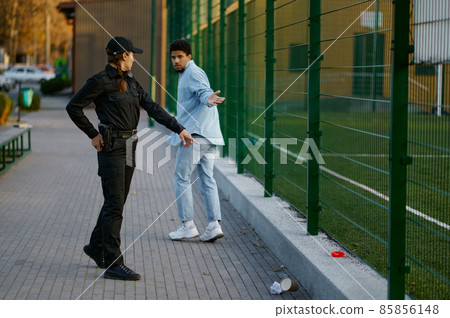 Policewoman making remark to passerby for rubbish 85856148