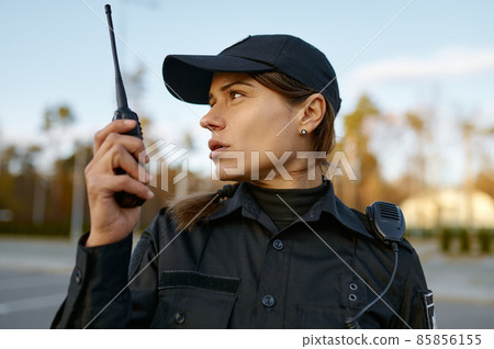 Portrait of female cop communicating on walkie-talkie Portrait of female cop communicating on walkie-talkie 85856155