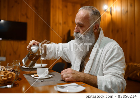 Man pouring tea during rest in sauna Man pouring tea during rest in sauna 85856214