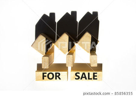 House for sale symbol. Concept words 'For sale' on wooden blocks near miniature houses from shadows. Beautiful white background, copy space. Business and house for sale concept. 85856355