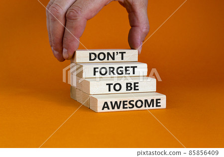 Do not forget awesome symbol. Concept words 'Do not forget awesome' on wooden blocks on a beautiful orange background. Businessman hand. Business, motivational, be awesome concept. 85856409