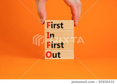 FIFO first in first out symbol. Concept words FIFO first in first out on wooden blocks. Beautiful orange table, orange background. Businessman hand. Business FIFO first in and out concept. Copy space. FIFO first in first out symbol. Concept words FIFO first in first out on wooden blocks. Beautiful orange table, orange background. Businessman hand. Business FIFO first in and out concept. Copy space. 85856410