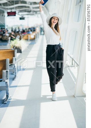 Cheerful businesswoman waiting for her flight at airport. Young woman at the airport. Travel. A young woman is waiting her flight in waiting hall in airport. 85856791