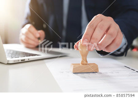Businessman working in office with stamp Businessman working in office with stamp 85857594
