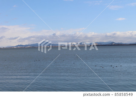 琵琶湖風景與平靜的湖面與藍天、雲彩、山、橋樑、大廈和水禽 85858549
