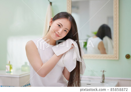 Young woman with long hair doing hair care Young woman with long hair doing hair care 85858872