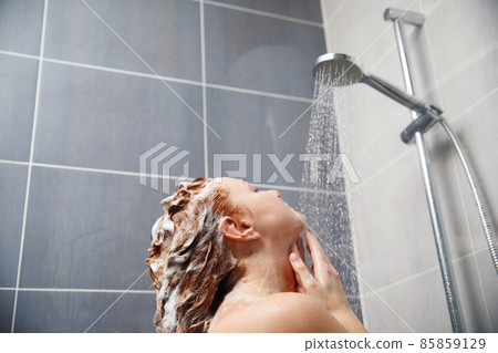 Rear view of a woman taking a shower in the bathroom. 85859129