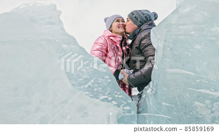Couple has fun during winter walk against background of ice of f 85859169