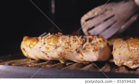 Delicious juicy meat steak cooking on the grill. Cook grilling fresh chicken breast. Fry chicken fillet on electric roaster. Slow motion. Delicious juicy meat steak cooking on the grill. Cook grilling fresh chicken breast. Fry chicken fillet on electric roaster. Slow motion. 85859426