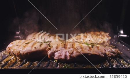 Delicious juicy meat steak cooking on the grill. Cook grilling fresh chicken breast. Fry chicken fillet on electric roaster. Slow motion. Delicious juicy meat steak cooking on the grill. Cook grilling fresh chicken breast. Fry chicken fillet on electric roaster. Slow motion. 85859430