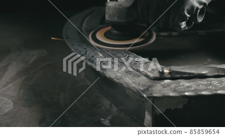 Forge workshop. Smithy manual production. Polish metal with an angle grinder with an abrasive nozzle. Polishing iron. Forge workshop. Smithy manual production. Polish metal with an angle grinder with an abrasive nozzle. Polishing iron. 85859654