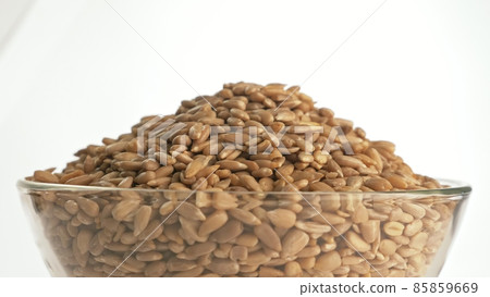 Nuts sunflower rotate are on a table in a plate. Snack in transparent dish on an isolated white background are spinning moving. Nuts sunflower rotate are on a table in a plate. Snack in transparent dish on an isolated white background are spinning moving. 85859669