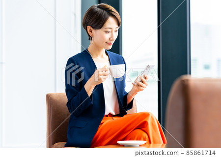 Middle-aged woman looking at a smartphone at a cafe 85861714