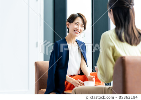 Middle-aged woman relaxing with friends at a cafe 85862184