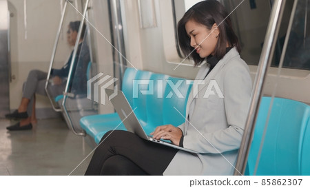 businesswoman sitting using laptop computer working on the subway train 85862307