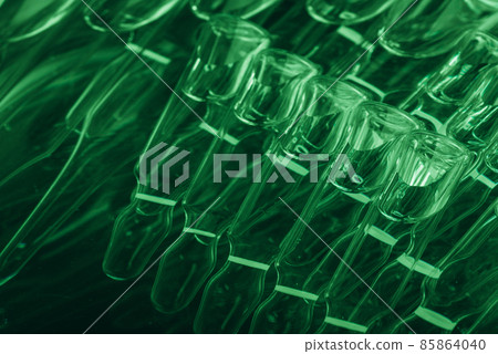 Glass medical ampoule vial for injection. Medicine is liquid sodium chloride with of aqueous solution in ampulla. Close up. Bottles ampule multicolor. Glass medical ampoule vial for injection. Medicine is liquid sodium chloride with of aqueous solution in ampulla. Close up. Bottles ampule multicolor. 85864040