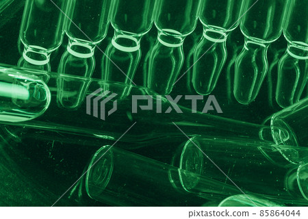 Glass medical ampoule vial for injection. Medicine is liquid sodium chloride with of aqueous solution in ampulla. Close up. Bottles ampule multicolor. 85864044