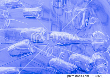 Glass medical ampoule vial for injection. Medicine is liquid sodium chloride with of aqueous solution in ampulla. Close up. Bottles ampule multicolor. 85864102