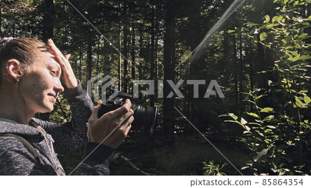 Traveler photographing scenic view in forest. One caucasian woman shooting nice magic look. Girl take photo video on dslr mirrorless camera. 85864354