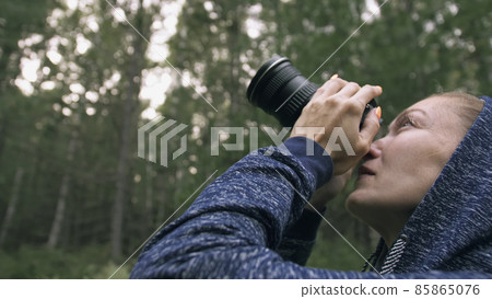 Traveler photographing scenic view in forest. One caucasian woman shooting close up look. Girl take photo video on dslr mirrorless camera. 85865076