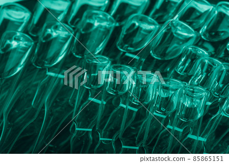 Glass medical ampoule vial for injection. Medicine is liquid sodium chloride with of aqueous solution in ampulla. Close up. Bottles ampule multicolor. Glass medical ampoule vial for injection. Medicine is liquid sodium chloride with of aqueous solution in ampulla. Close up. Bottles ampule multicolor. 85865151