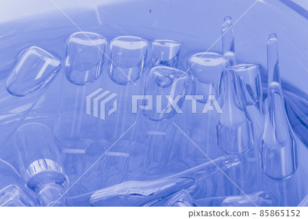 Glass medical ampoule vial for injection. Medicine is liquid sodium chloride with of aqueous solution in ampulla. Close up. Bottles ampule multicolor. Glass medical ampoule vial for injection. Medicine is liquid sodium chloride with of aqueous solution in ampulla. Close up. Bottles ampule multicolor. 85865152