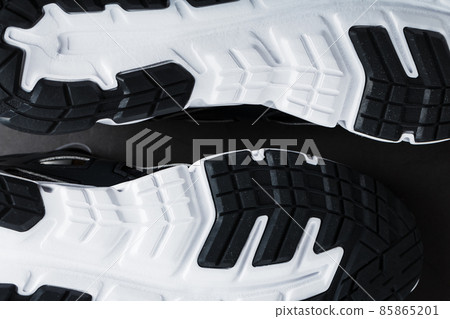 The black and white sole of trendy sports sneakers is a close-up in full screen. 85865201
